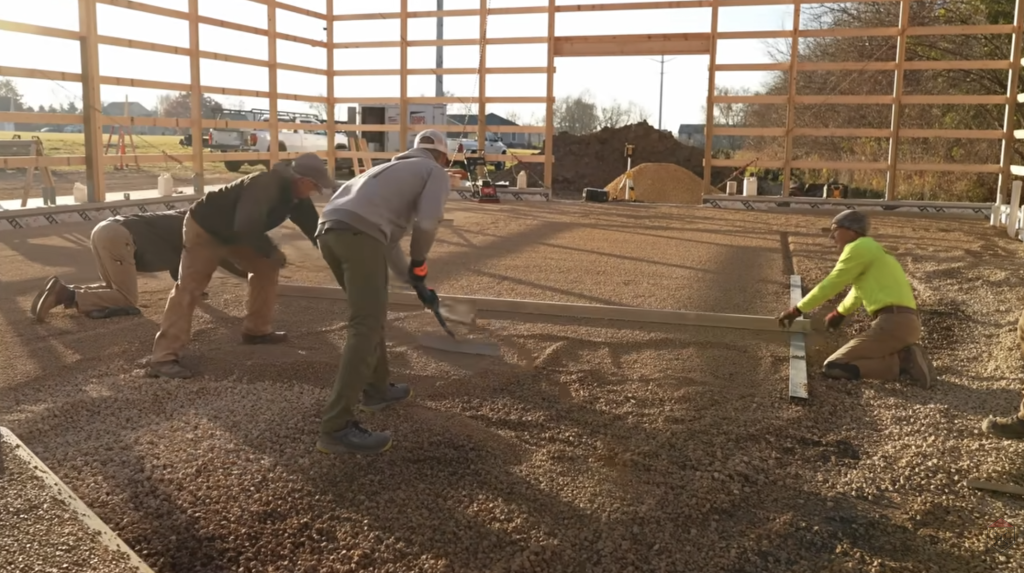 Lightweight aluminum rails guided the gravel grading, helping the team achieve a dead-flat surface ready for Heat-Sheet® panels.