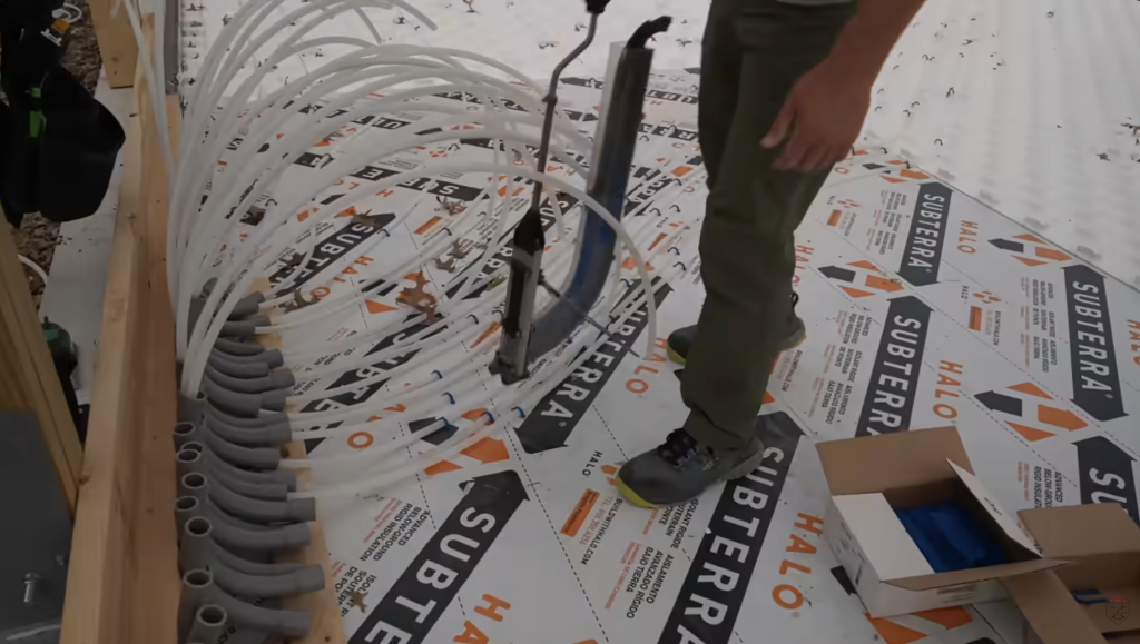 PEX is stapled near the manifold to manage transitions, prevent movement, and keep the system organized.